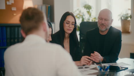 coworkers discussing strategy in meeting at office.