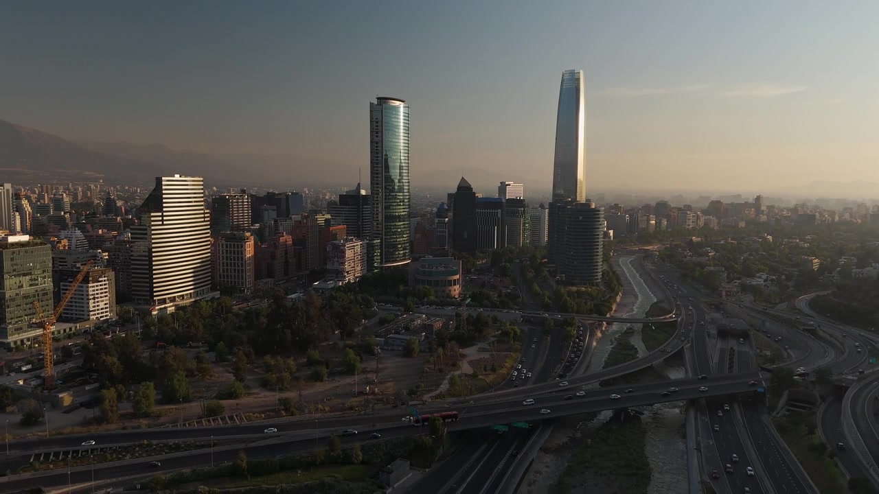 Ripresa aerea di Santiago, Cile, con moderni grattacieli e traffico autostradale durante un tramonto velato