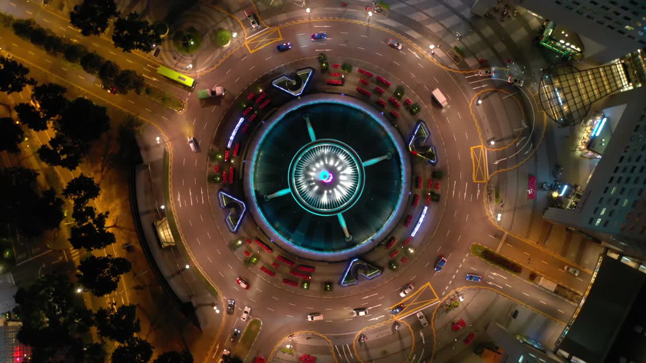 volo di illuminazione notturna sopra la città di singapore famosa cerchio di traffico del centro panoramico aereo topdown 4k
