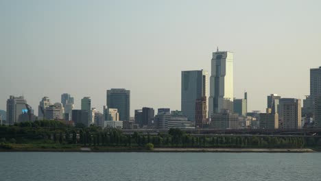 한국 무역 타워와 한강 물가에서 일몰 빛에 많은 고층 빌딩과 높은 건물, 자동차 교통