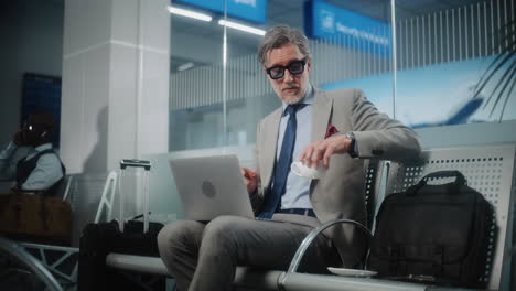 businessman working on laptop in airport