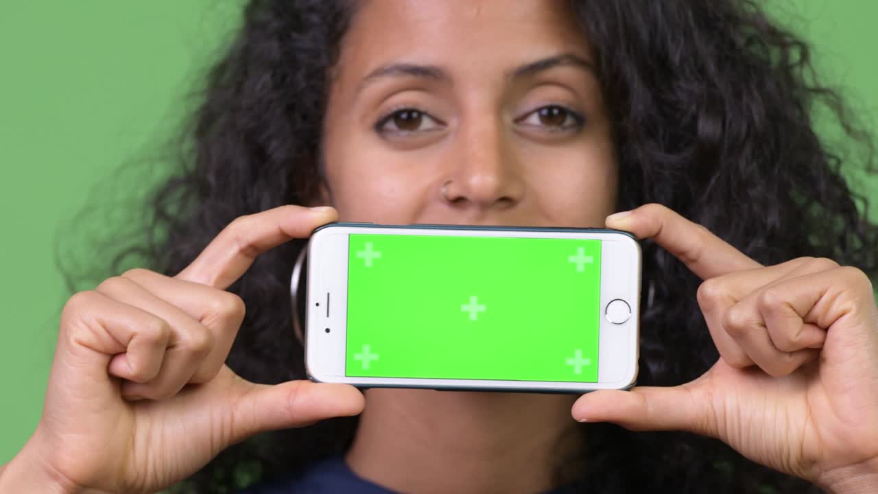 Young beautiful Hispanic businesswoman showing phone
