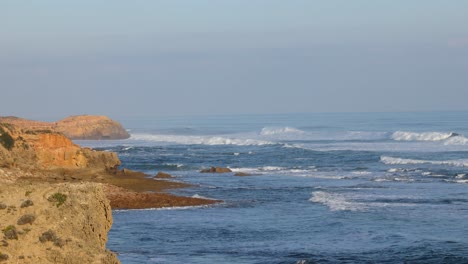 waves crashing against rocky coastline at sunset