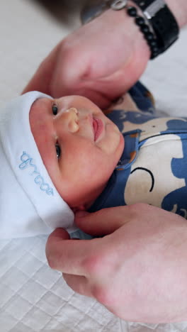 father gently holding and caring for newborn baby