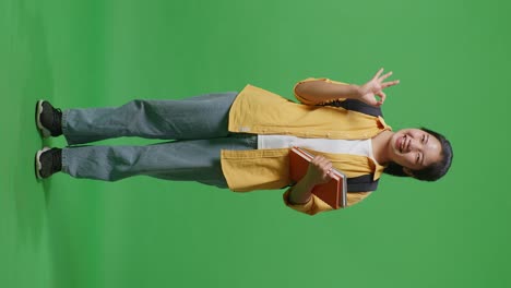 happy student showing ok gesture with books and backpack