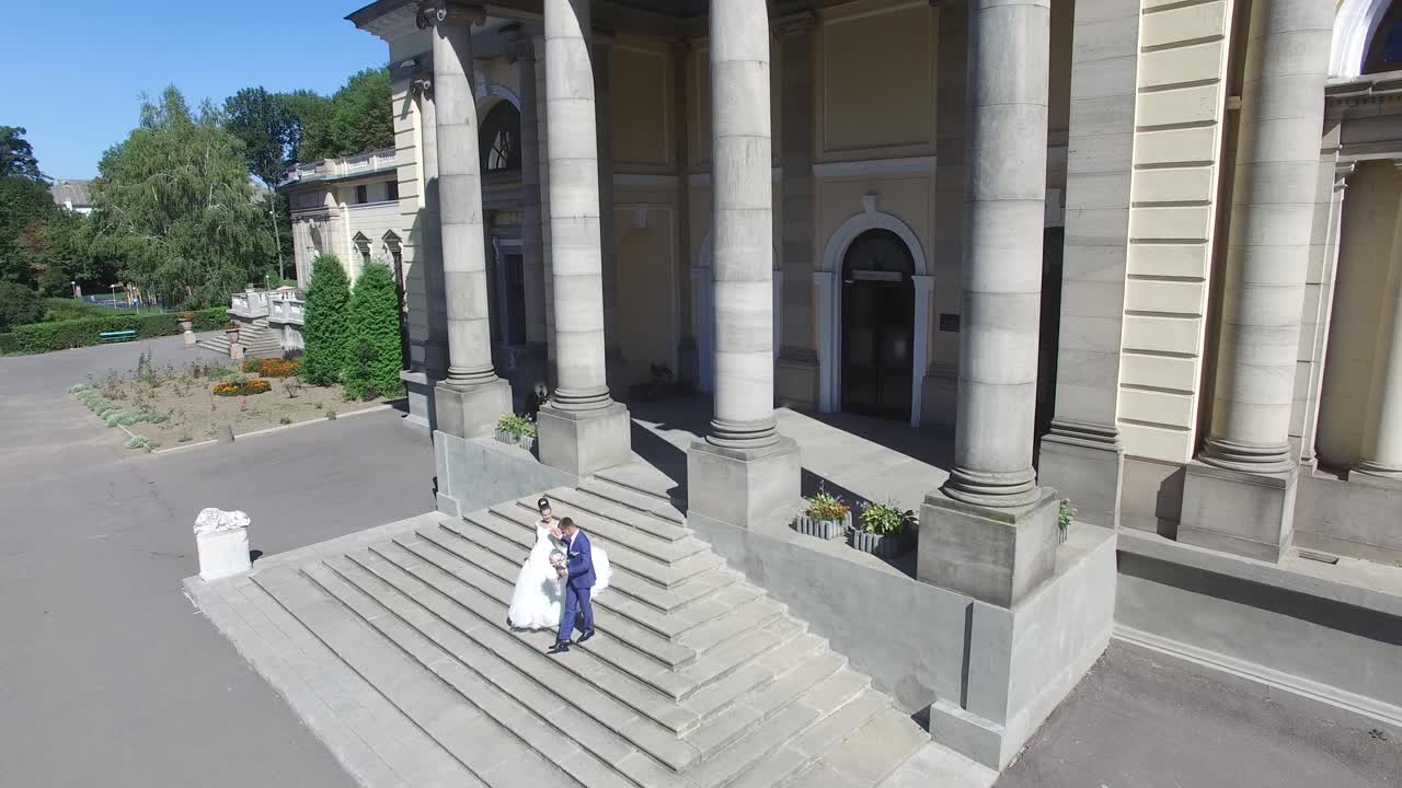 Romantic Sensual Moment. Aerial shot of a beautiful young wedding couple walking on stairs of romantic antique palace