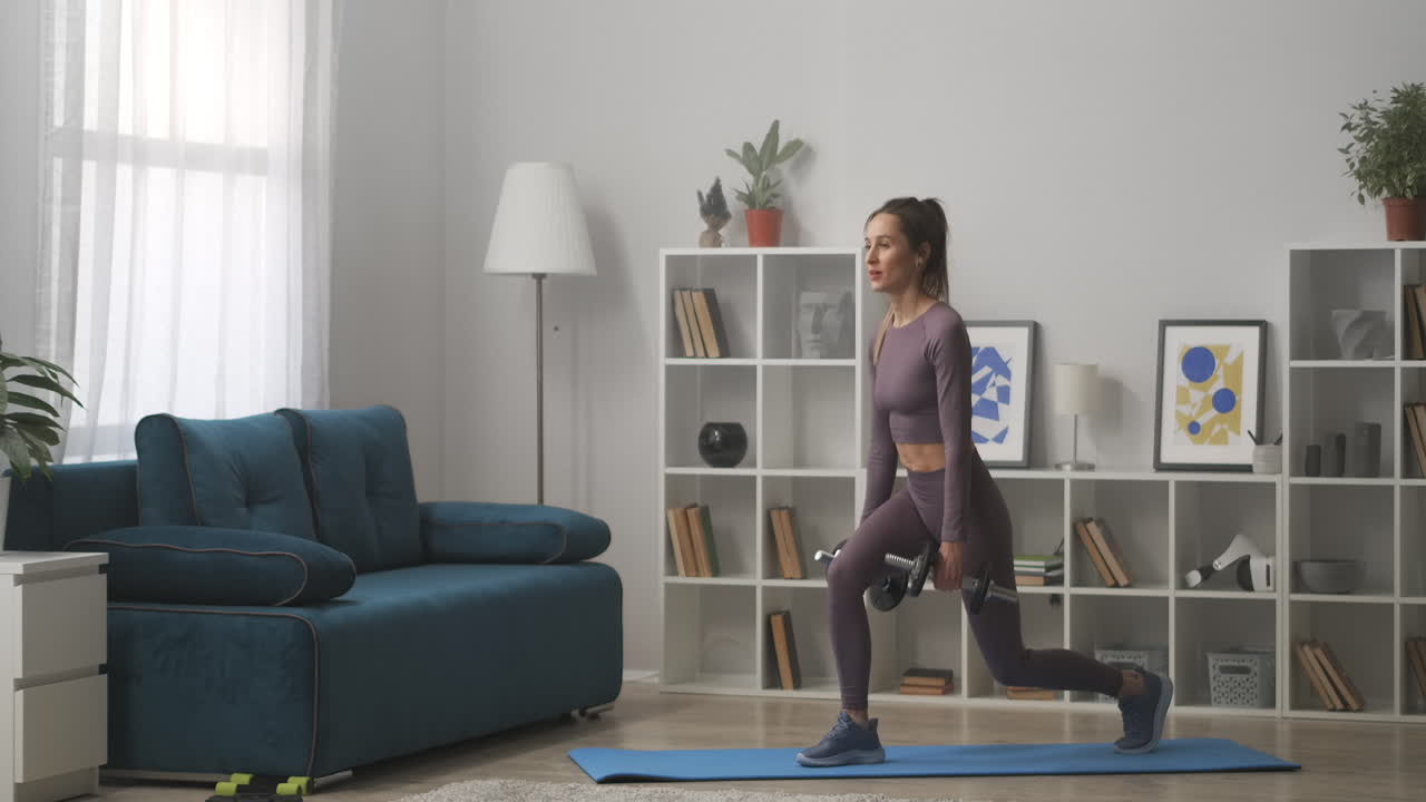 mulher magra está fazendo exercícios para as pernas em casa agachando-se com halteres nas mãos cuidando de boa forma do corpo perdendo peso