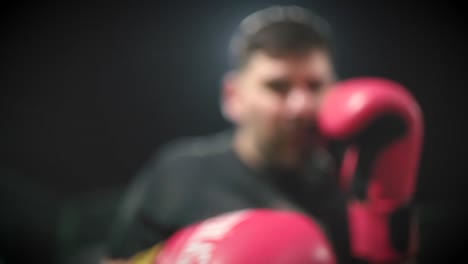 boxeador lanzando jabs y puñetazos con guantes de boxeo a la cámara en cámara lenta con estrecha profundidad de campo