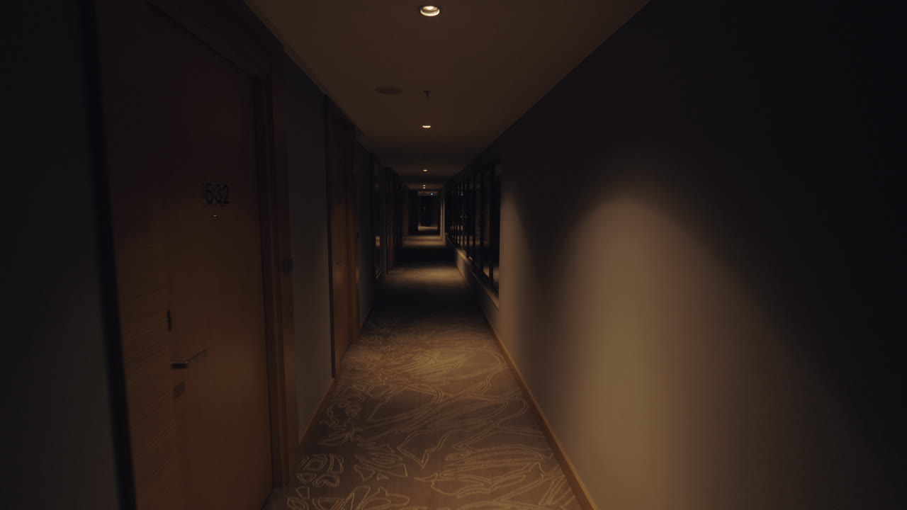 Una ripresa steadicam di un lungo e buio corridoio d'hotel con grandi finestre