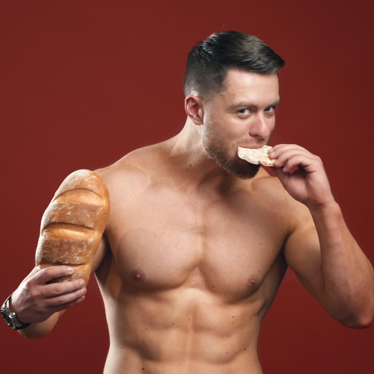 Healthy food choices. Naked sportsman choosing between healthy and unhealthy bread for his muscular body. Portrait of handsome bodybuilder with bread in studio.
