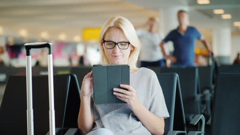 Frau-Benutzt-Ein-Tablet-Am-Flughafen