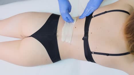 woman having back waxing treatment
