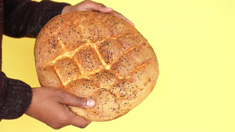 primer plano de una persona sosteniendo un pan recién horneado