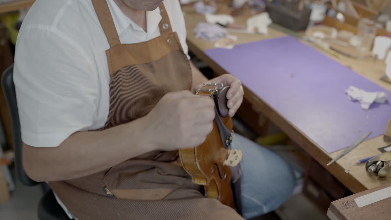 Artigiano con violino in un laboratorio professionale