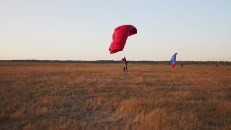 paracaidista aterriza en el campo después de desembarcar del avión en el fondo de otros paracaidistas