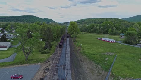An Aerial View of an Abandoned Narrow Gauge Coal Rail Road with Rusting Hoppers and Freight Cars and Support Building Starting to be Restored