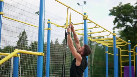 Strong man preparing doing exercises using rubber, bodybuilder workout with rubber outdoors