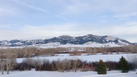 Boseman-Montana-Aerial-Winter-Mountain-View,-drone-flyover-and-tilt-up-over-snowy-suburban-park-at-golden-hour-in-4k