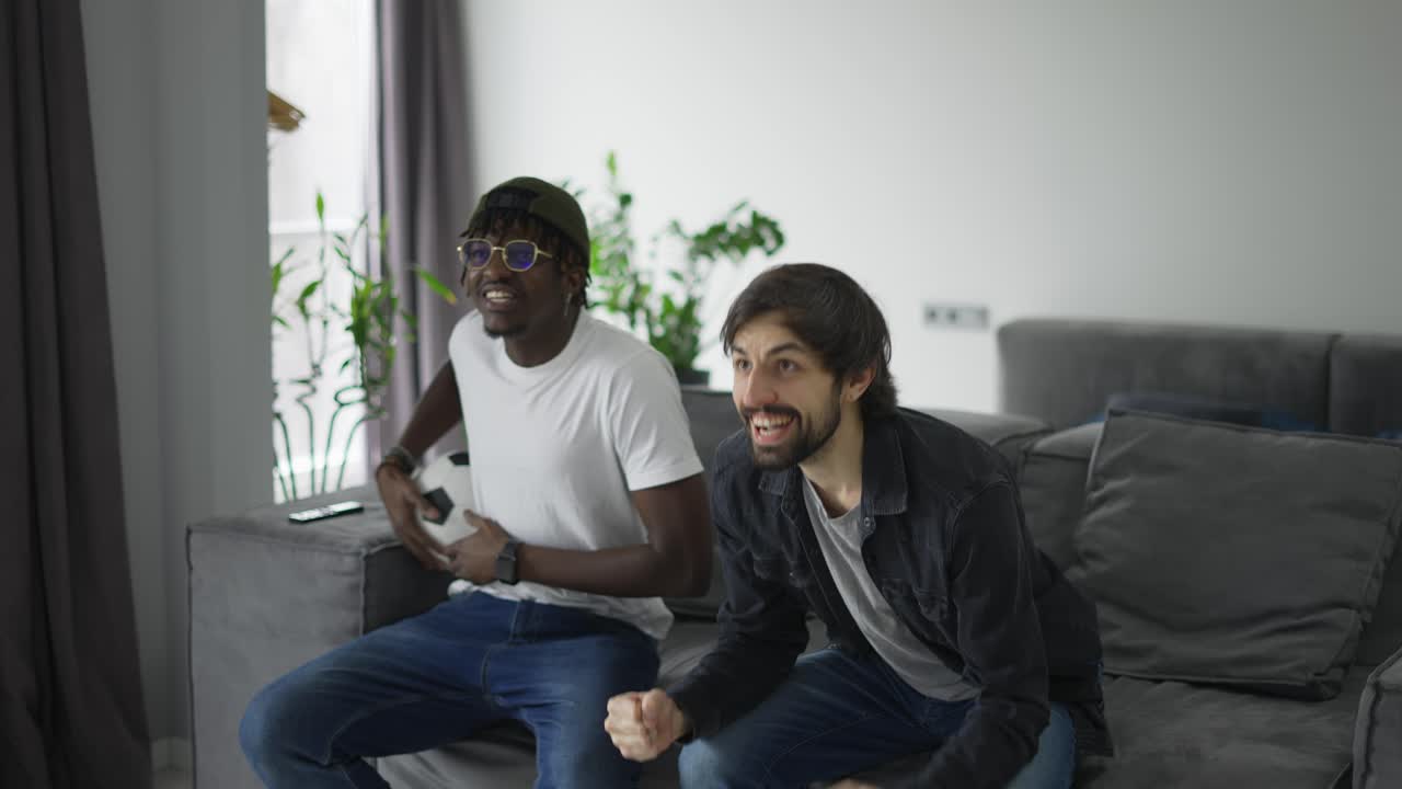amigos varones quedándose en casa para ver fútbol, rogando por un gol