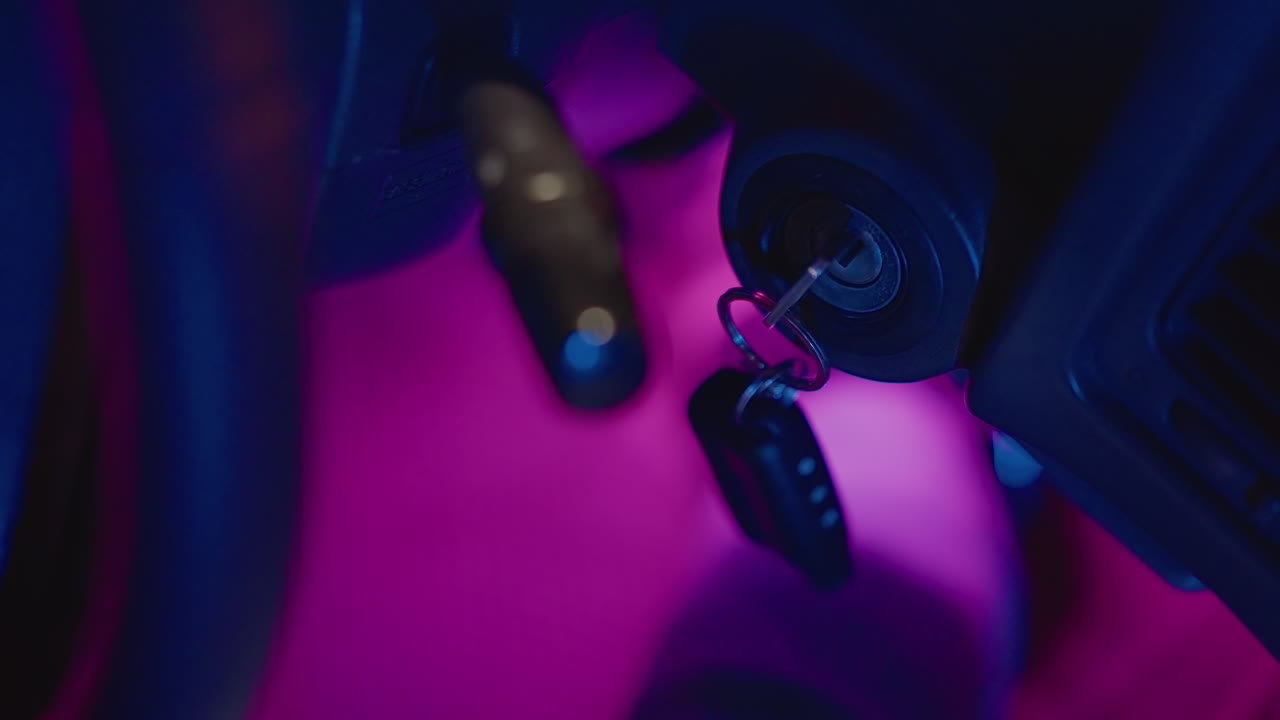Ignition glow moment, Closeup of glowing car key fob, Magnified scene showing key fob with magenta light, Detailed shot capturing fingers releasing keys over vehicle dashboard in quiet ambiance