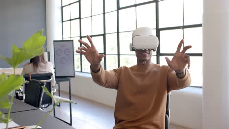 using vr headset, african american man interacting with virtual interface in modern office