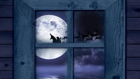 marco de ventana de madera contra santa claus en trineo siendo tirado por renos sobre el paisaje de invierno
