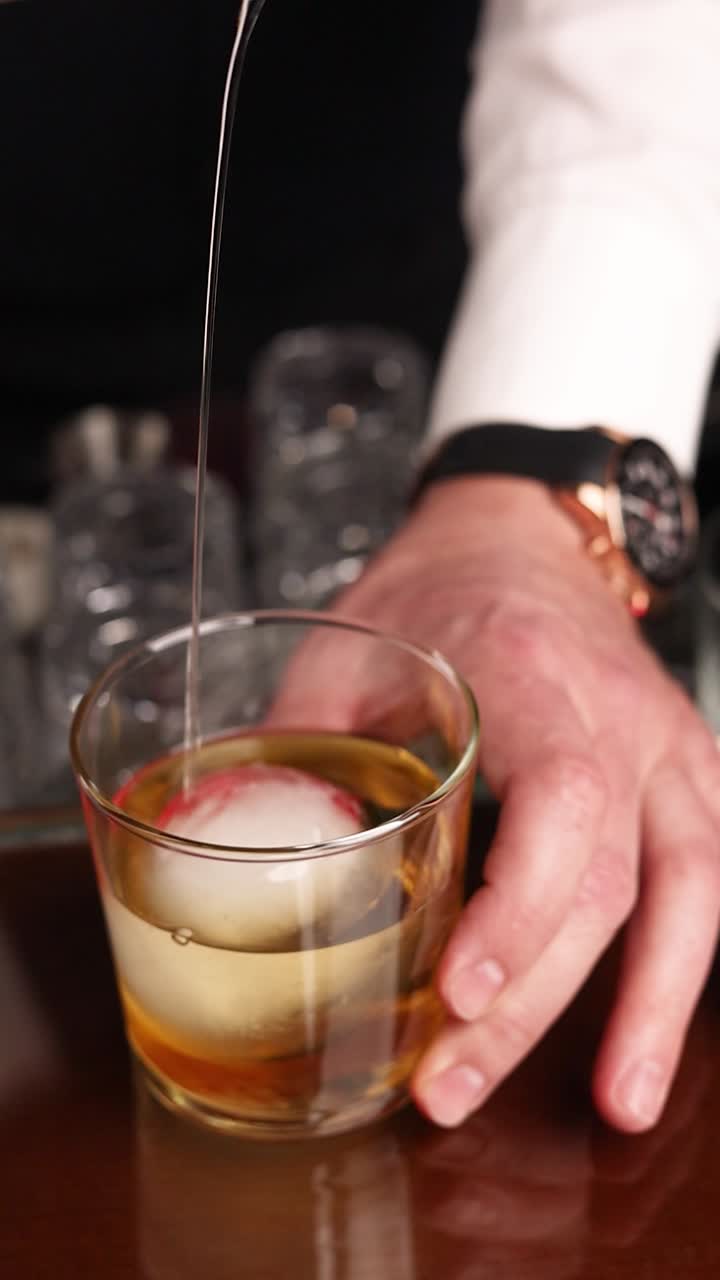 el camarero vertiendo un cóctel.