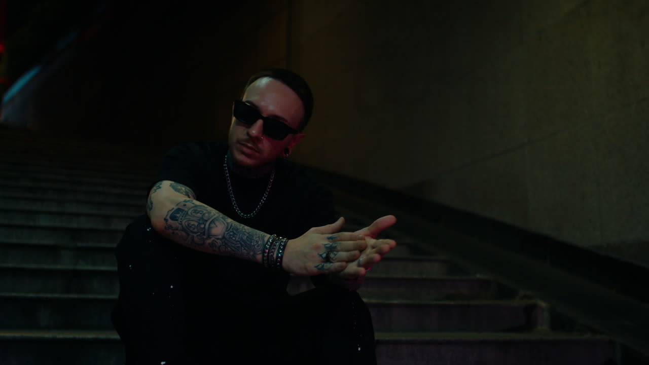 Night Portrait of a Tattooed Man in Stylish Sunglasses