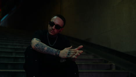 night portrait of a tattooed man in stylish sunglasses