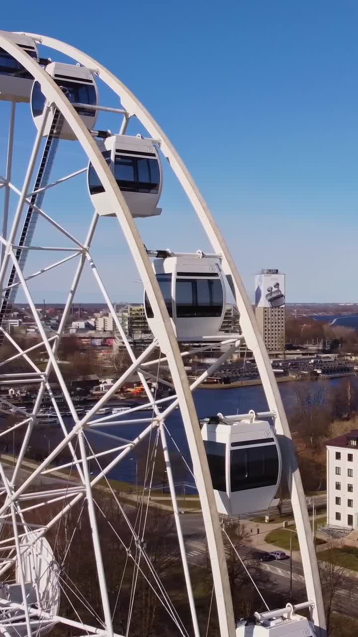 Ferris wheel cart and Riga skyline in background, aerial close up vertical view