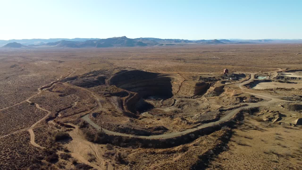 US, AZ, Kingman, Emerald Isle Mine, 2025-01-14 - Drone view of an open pit mine in the desert with equipment, tailings pile, at sunrise
