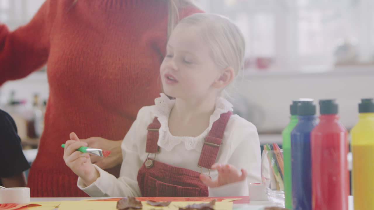 close up de la madre con los niños en casa haciendo artesanía y haciendo imágenes de hojas en la cocina