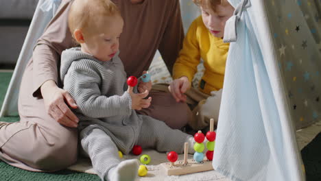 kids playing in teepee tent with mom
