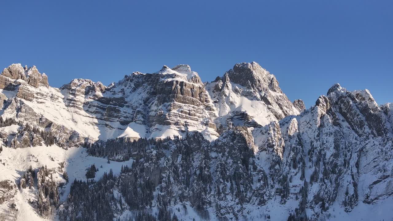 Cime innevate del Fronalpstock sotto un cielo azzurro e limpido, Glarona, Svizzera.