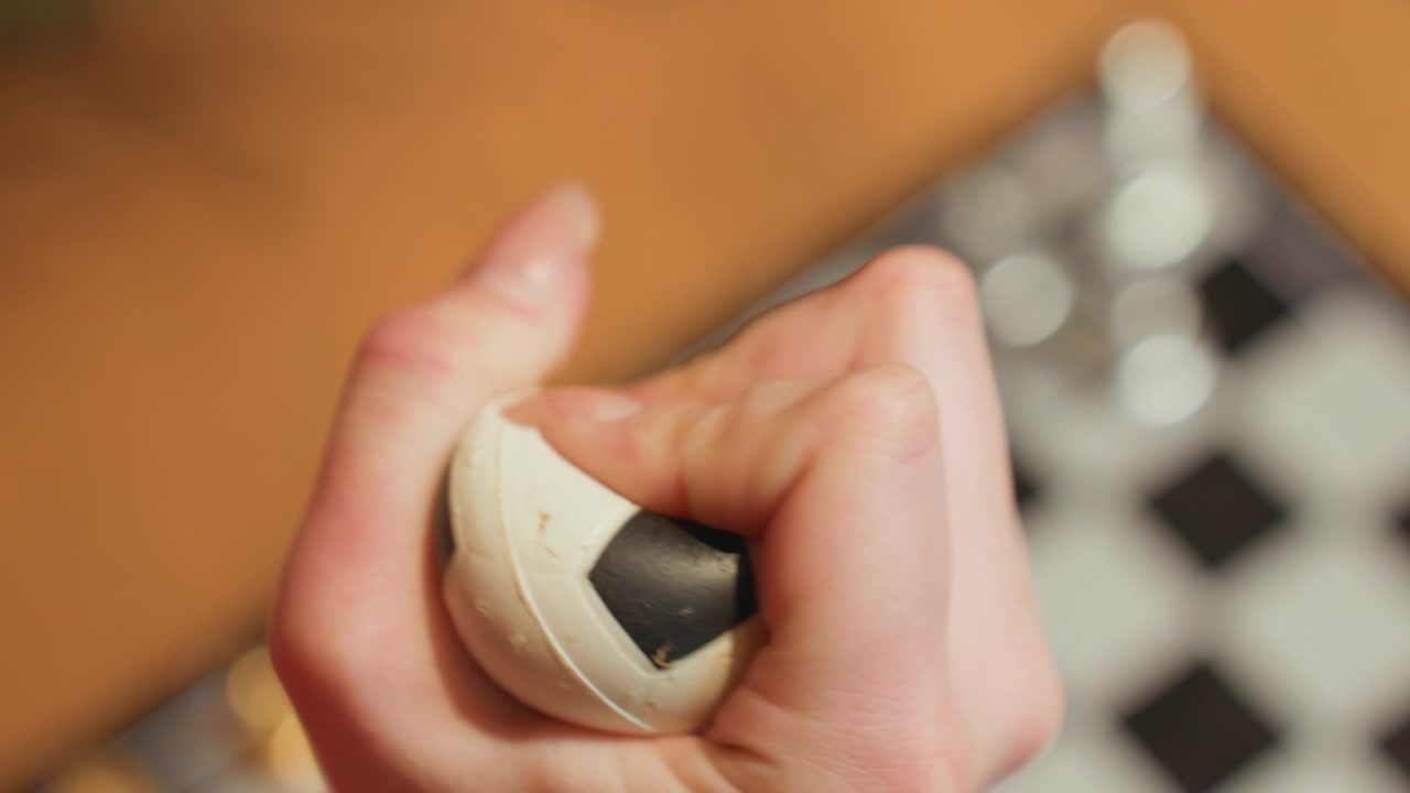 Nærbilde av hånd som klemmer en stressball formet som en fotball