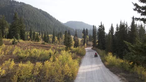 drone wide shot following atv rider towards utah wasatch mountains