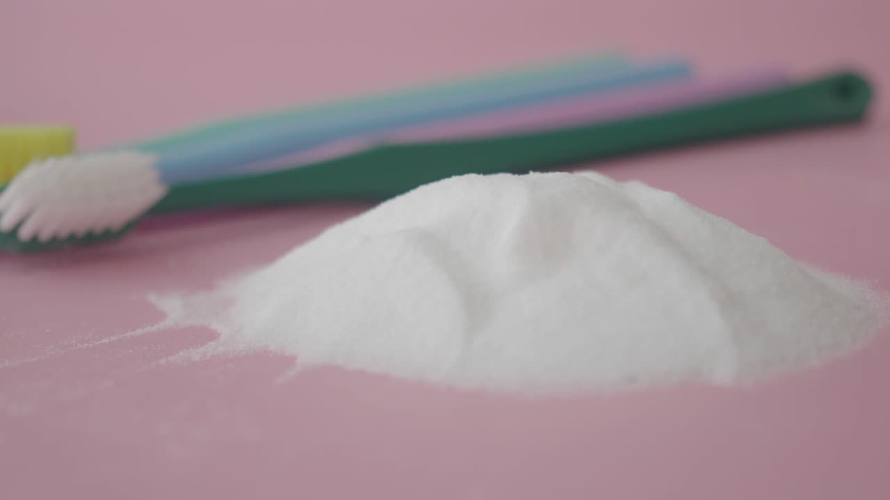Toothbrush and Baking Soda on Pink Background