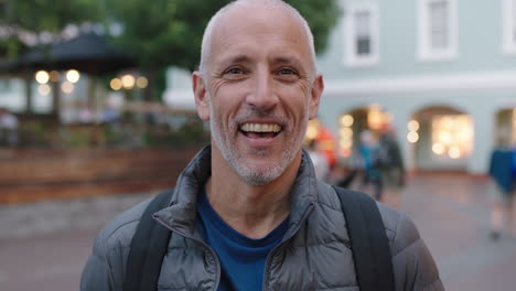 close-up-portrait-of-mature-attractive-caucasian-tourist-man-looking-cheerful-at-camera-laughing-urban-background