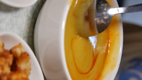 bowl of creamy soup with spoon and side dish