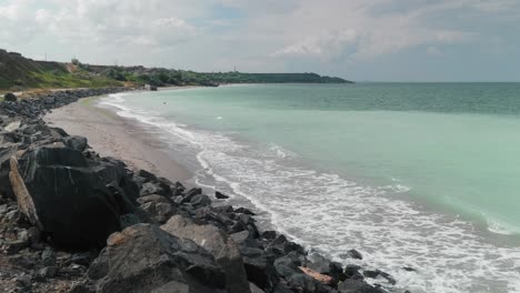 static shot of the black sea coastline at tuzla, constanta county, romania, on a warm summer day with calm waves and the seawater having a beautiful turquoise color