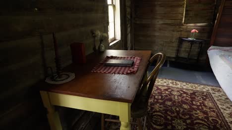 orbiting-shot-of-an-old-desk-with-a-journal-on-top-in-an-old-style-bedroom-with-all-wood-finishes