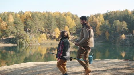 father and son fishing in autumn forest