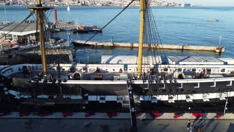drone shot flying sideways over an old docked portuguese vessel.