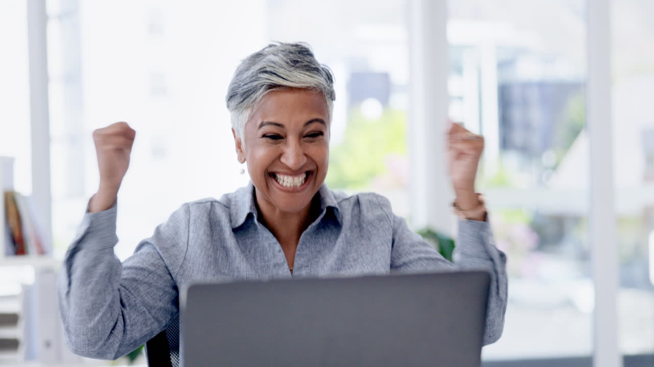 Senior woman, laptop and office with celebration