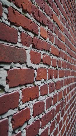 close-up, angled view of a red brick wall with visible mortar lines, creating a textured, dynamic