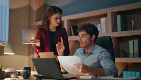 woman boss teaching trainee man at office looking laptop. manager rejoicing work