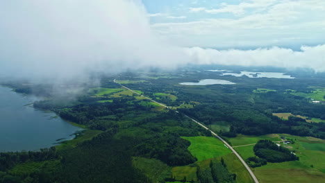 Endlose-Straße-Erstreckt-Sich-Durch-Eine-Landschaft-Aus-Wäldern,-Seen-Und-Feldern,-Luftaufnahme