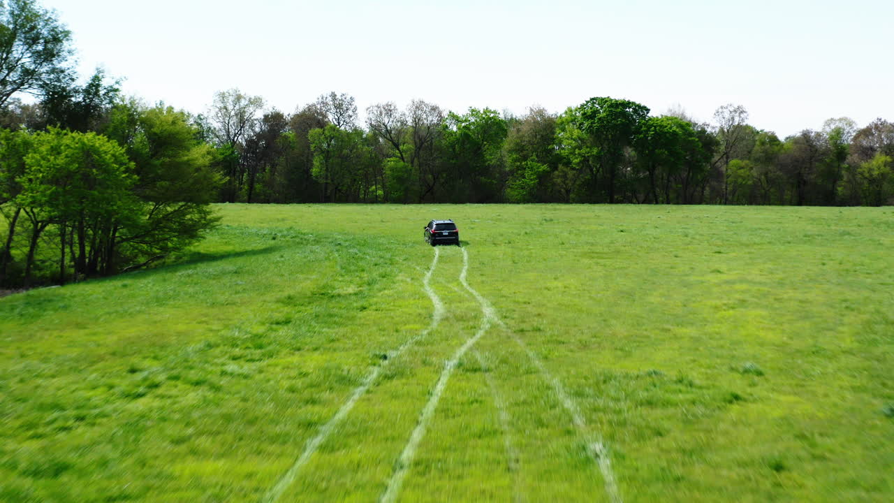 시골 근처의 푸른 들판을 여행하는 검은색 자동차