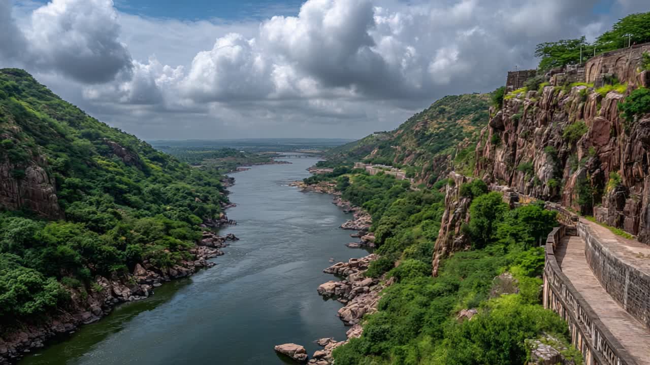 A Serene River Meanders Through Lush Green Hills Under a Dramatic Sky, Capturing the Beauty of Nature in a Tranquil Landscape