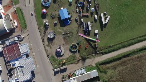 Aerial drone top shoot of an empty carnival with cars passing by its sides